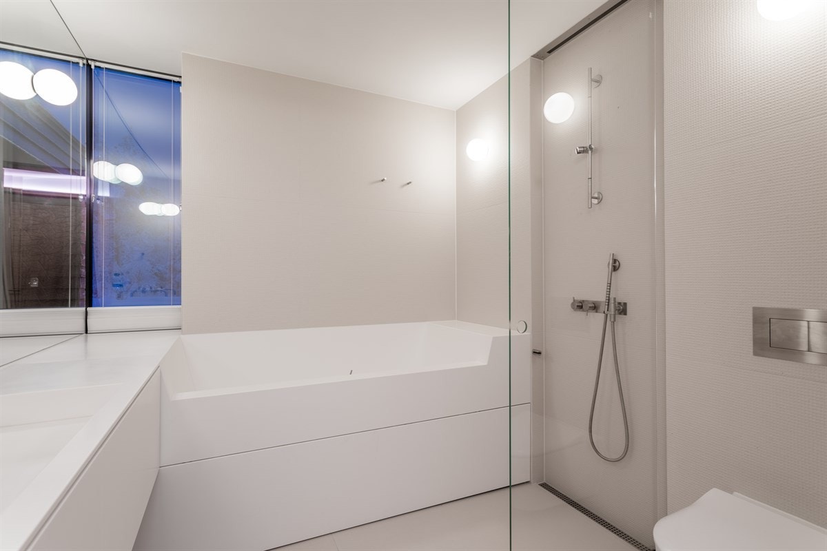 Dusjløsning med utfellbar glassvegg, vegghengt WC samt baderomsinnredning og badekar Galleribilde