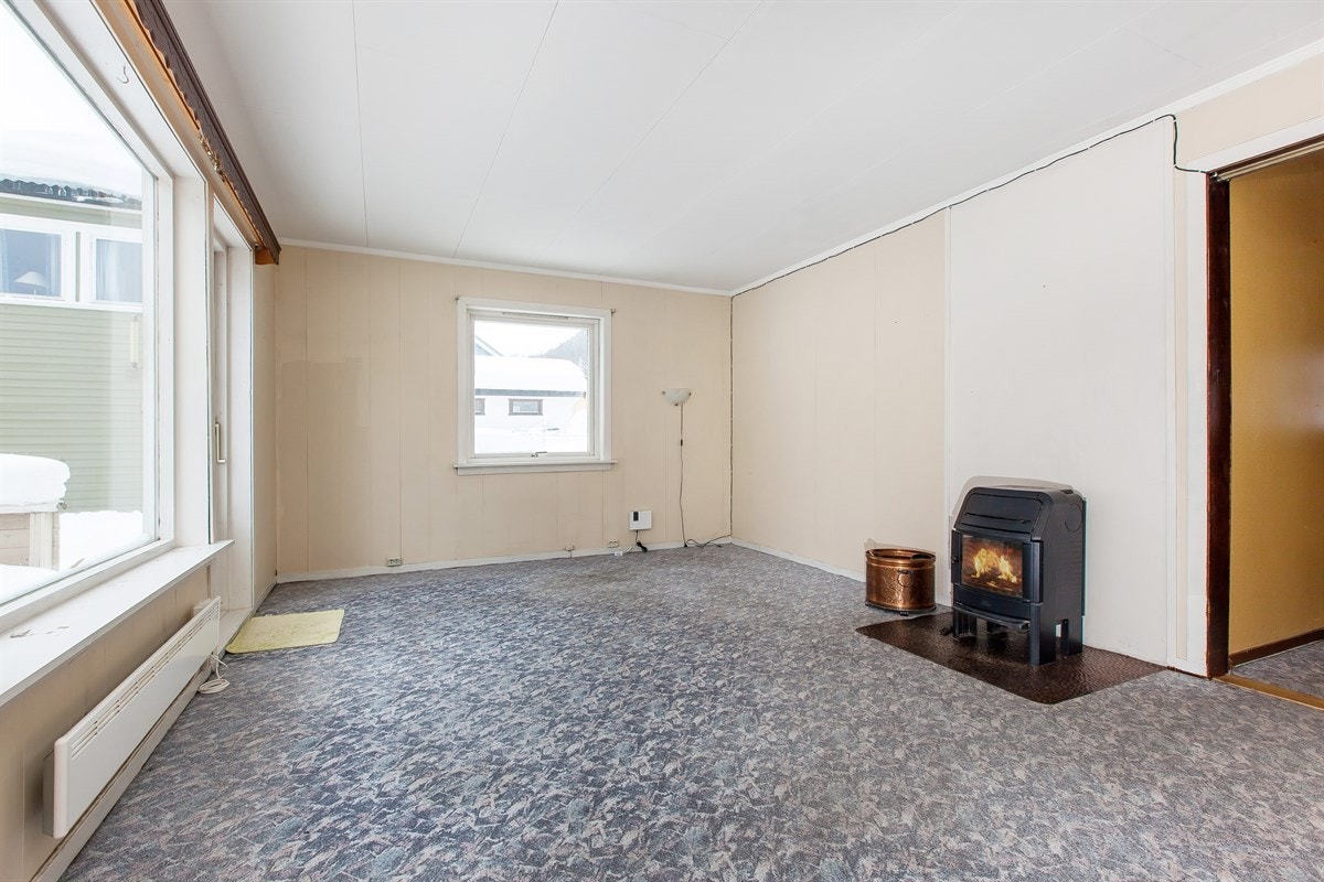 Boligen har en relativt romslig stue som er utstyrt med en trivelig vedovn Galleribilde