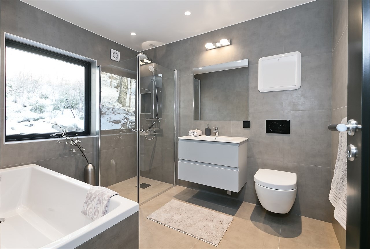 Stort og delikat hovedbad, innredet med badekar, dusj, servant med skuffer, speil/lys/stikkontakt og vegghengt toalett Galleribilde