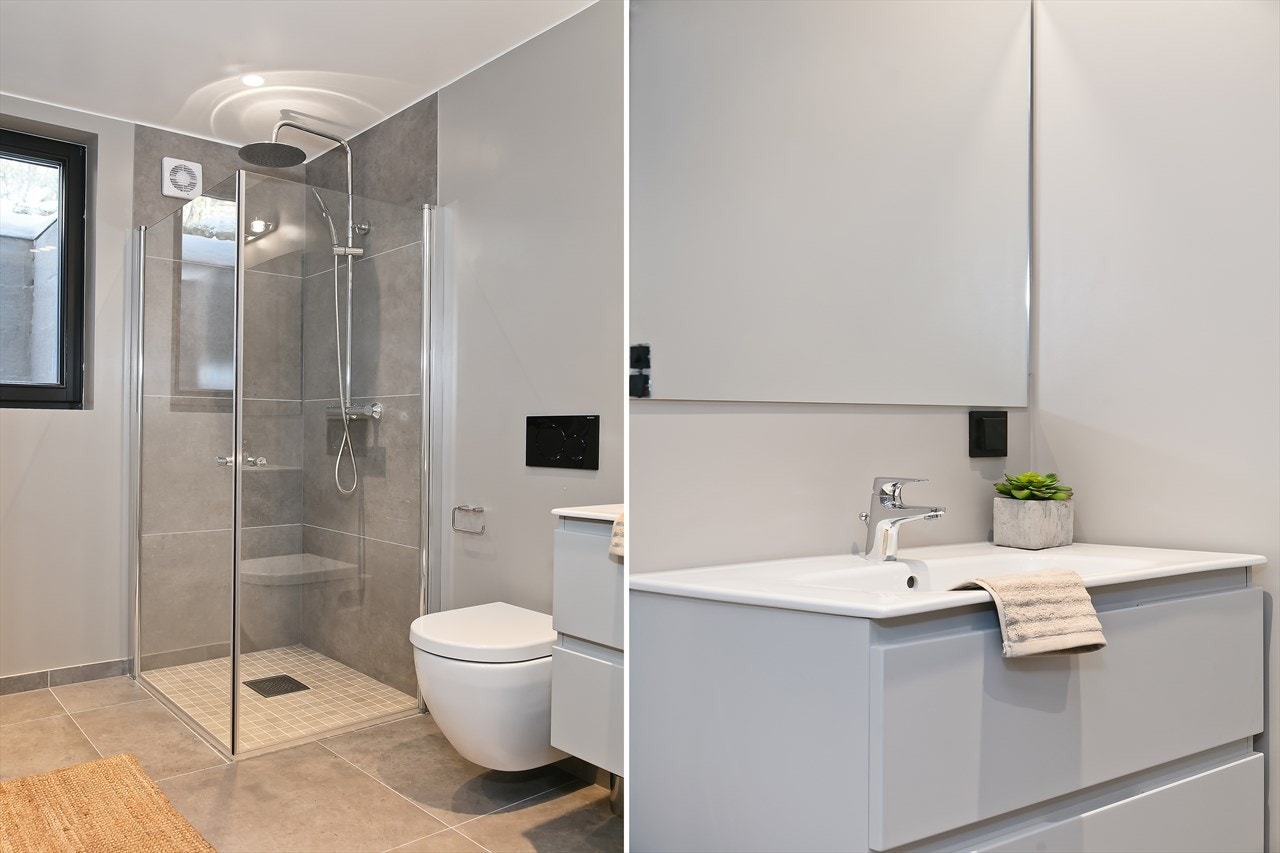 Badet er innredet med dusjnisje med glassvegger, servant i innredning med 2 skuffer under, speil og stikkontakt over servanten, vegghengt toalett Galleribilde