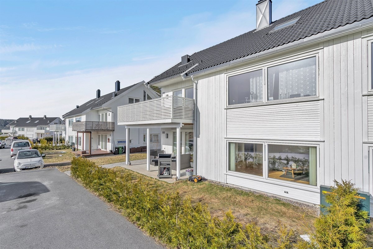 Leiligheten disponerer et trivelig uteområde med platting og gressplen Galleribilde