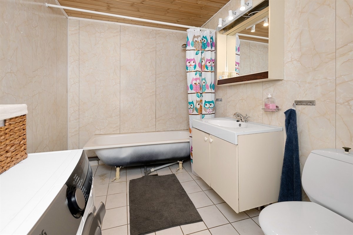Videre har utleiedelen et praktisk bad med lyse gulvfliser og vegger kledd med marmorerte våtromsplater. Galleribilde