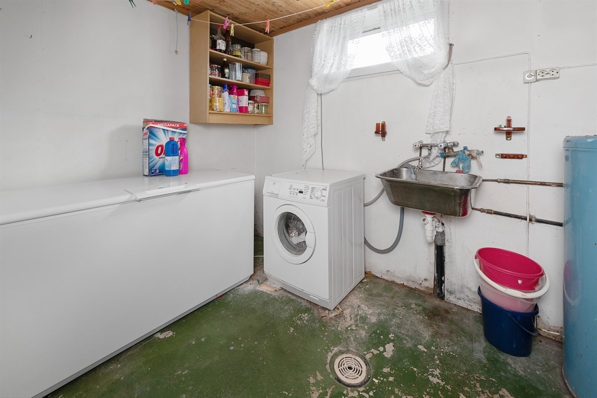 Vaskerommet ligger i underetasjen og har grovstøpt gulv og lysmalte plater på vegger. Innredningen består av en utslagsvask, en varmtvannsbereder og opplegg for vaskemaskin. Galleribilde