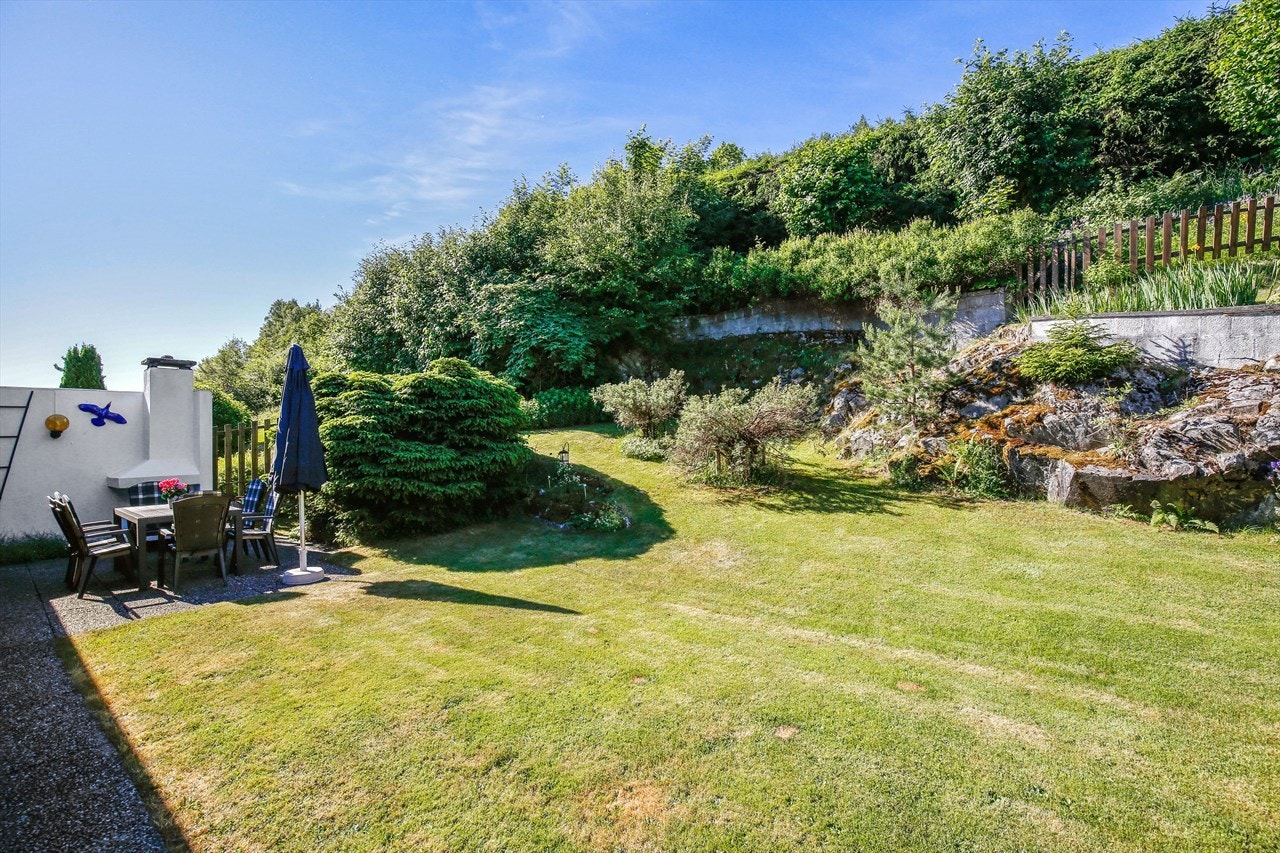 På baksiden av boligen har hagen synlig fjell og et rikt utvalg av fargerike stauder, steinbedsplanter, bærbusker og nåletrær. Galleribilde