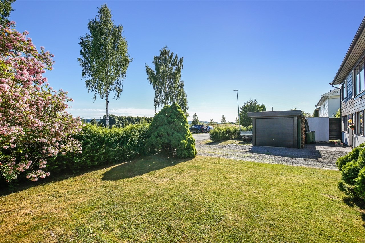 Hagen er vakkert opparbeidet med plen, frodige prydbusker, klatreplanter og trær. Galleribilde