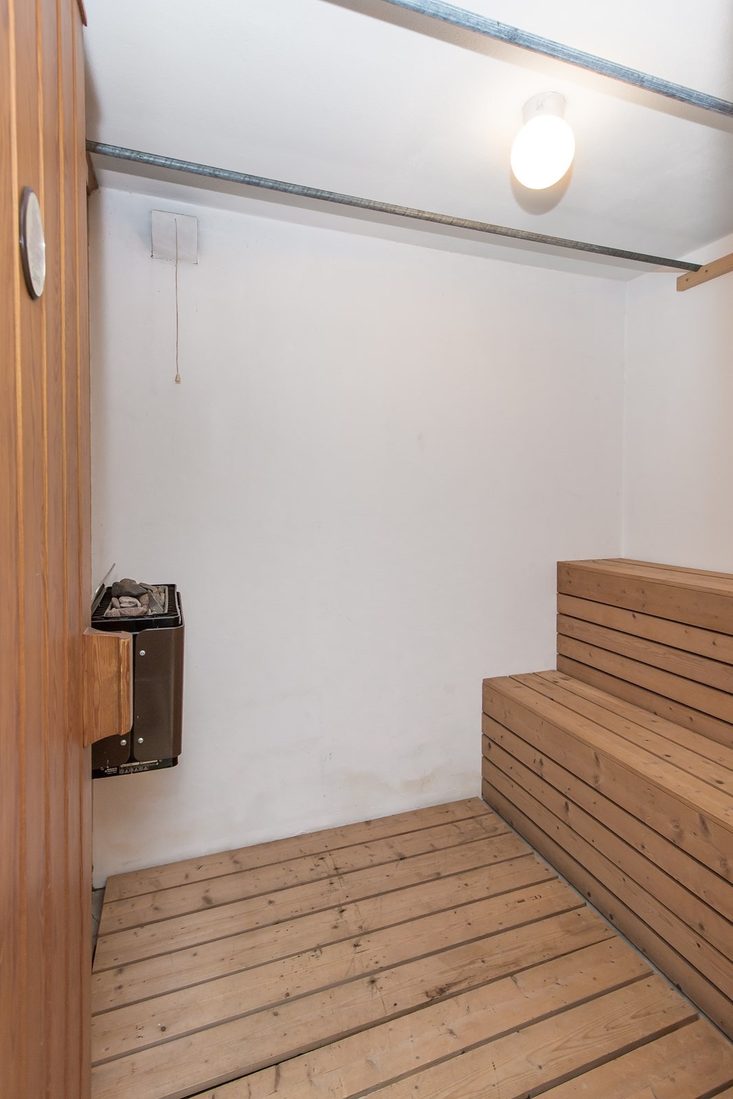 Innenfor badet er en badstue med benkeinnredning og ovn. Galleribilde