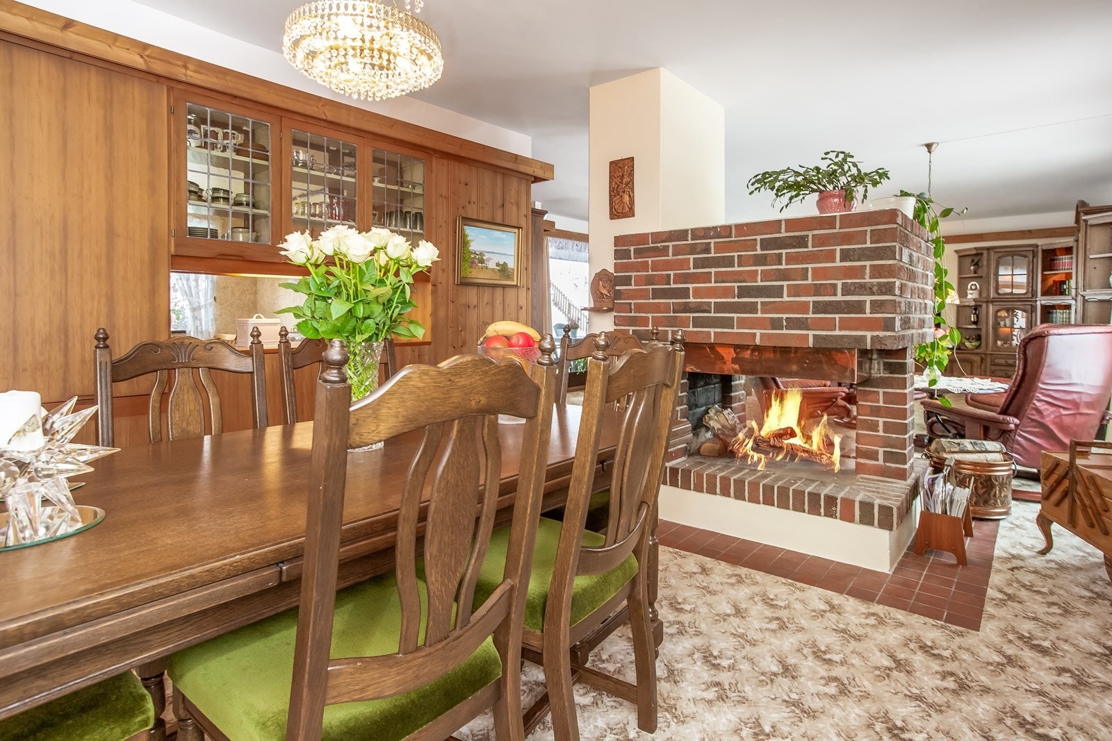 Midt i rommet er en åpen peis i teglstein, med innsyn til flammene fra begge sider. Galleribilde