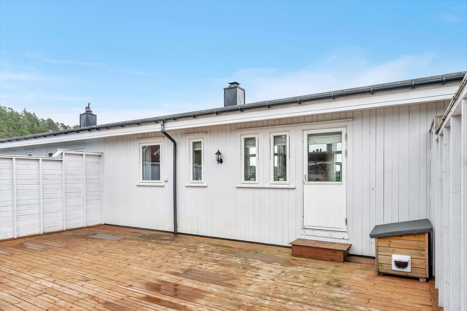 Utgang fra stuen til en stor terrasse på baksiden av boligen. Galleribilde