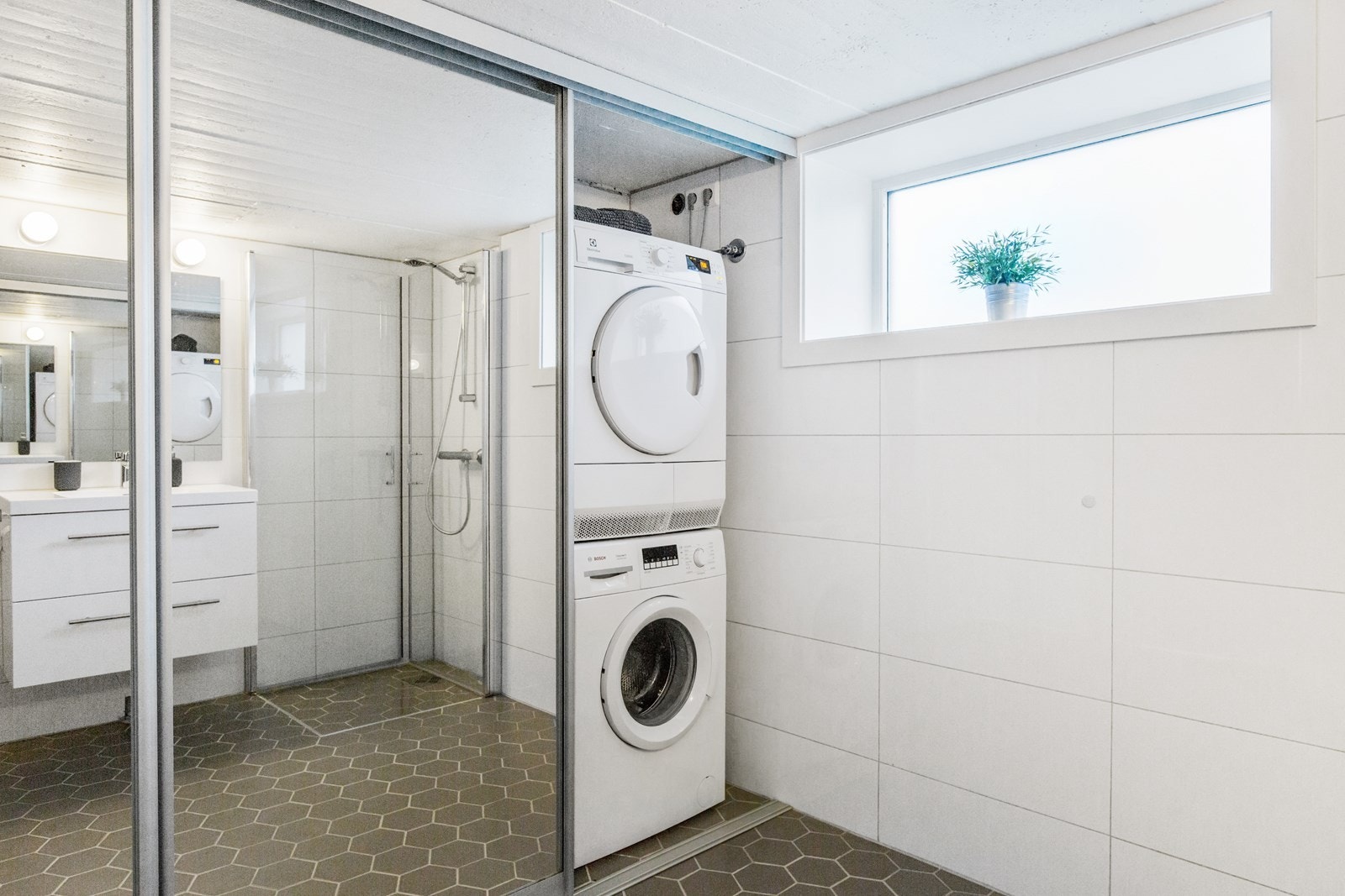 Nytt bad, opplegg til vaskemaskin skjult bak skyvedører. Galleribilde