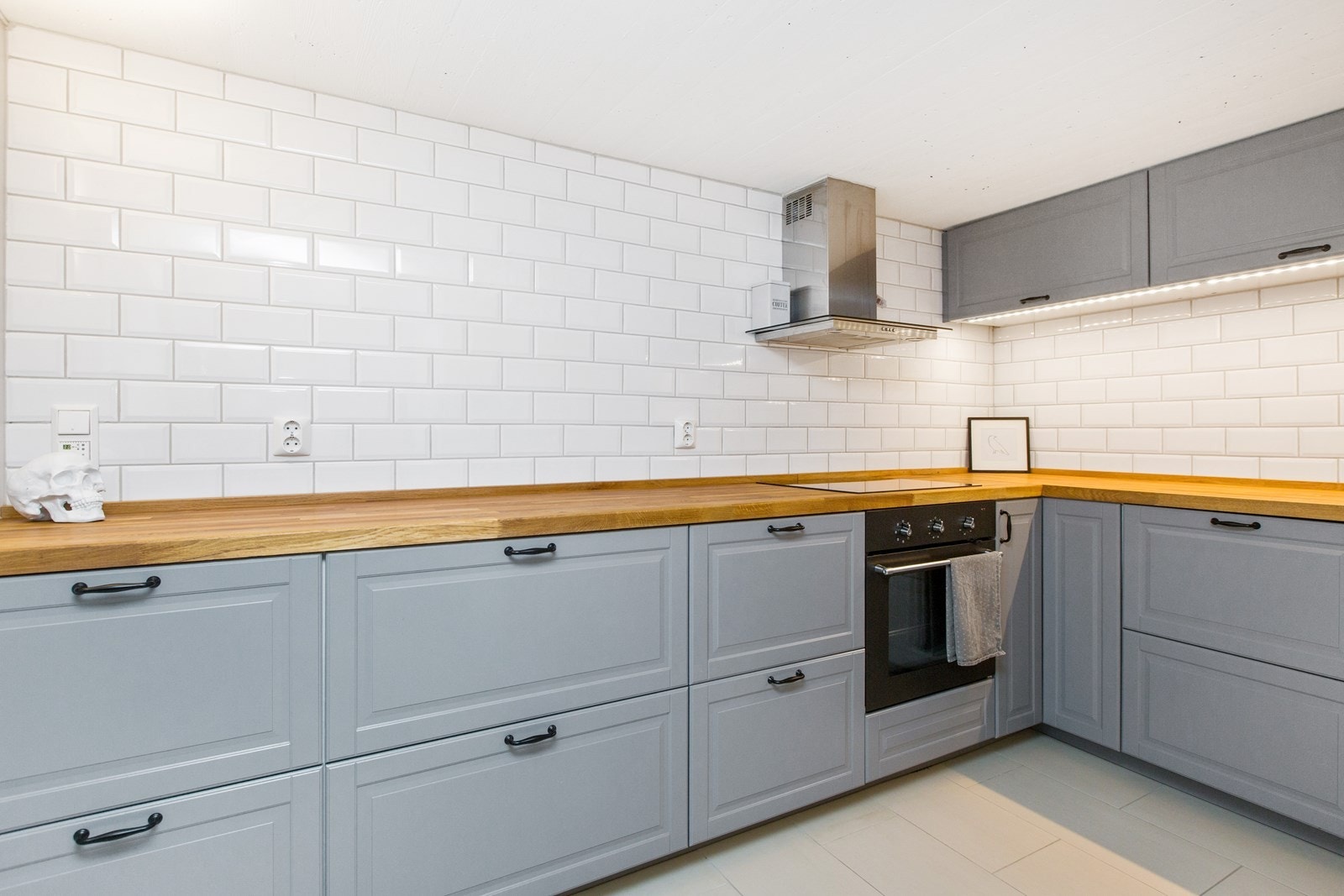 Kjøkken, grå profilert innredning med integrert komfyr, platetopp og oppvaskmaskin. Ventilator. Galleribilde