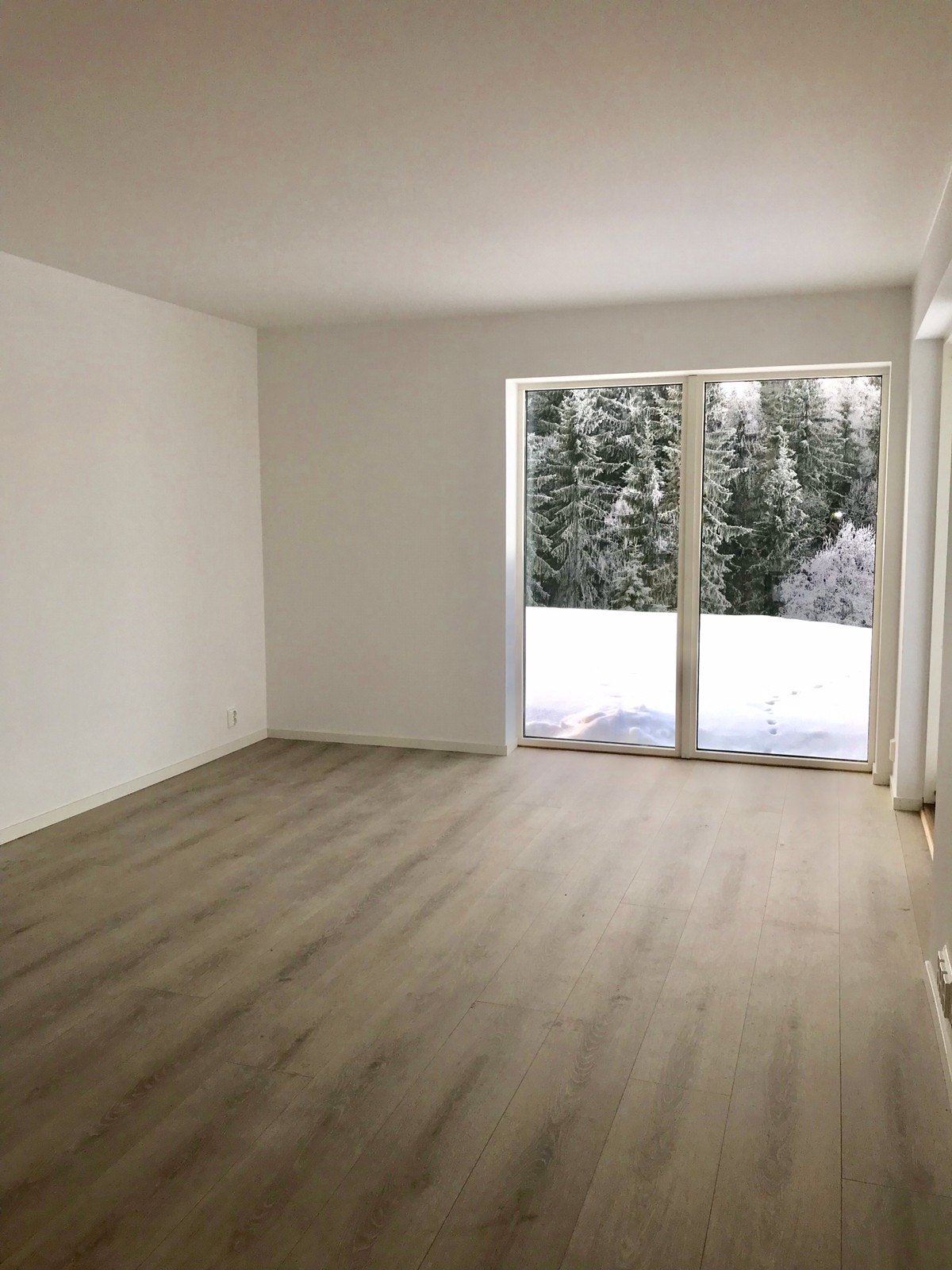 Lys og romslig stue med utsyn og utgang til terrasse Galleribilde