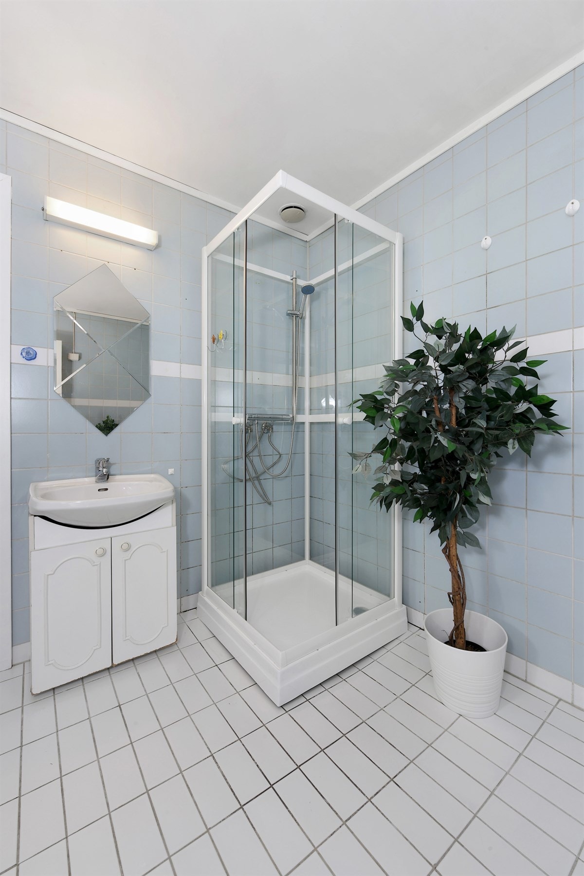 Det romslige badet har flislagte flater, og er utstyrt med dusjkabinett og varmtvannsbereder, begge av nyere dato. Galleribilde