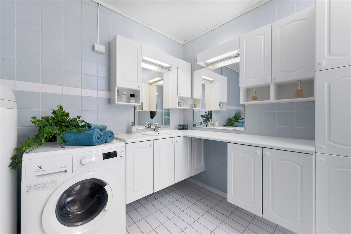Badet har svært god lagringsplass i stor innredning med profilerte fronter, en rekke skap, laminatbenkeplate, servant og to speil med belysning. I tillegg er det en mindre innredning med servant, speil og lys. Galleribilde