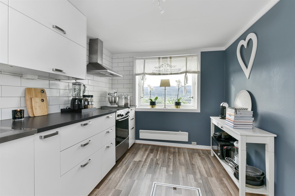 Kjøkkenet er pent med vegger i en moderne, dypblå farge. Galleribilde