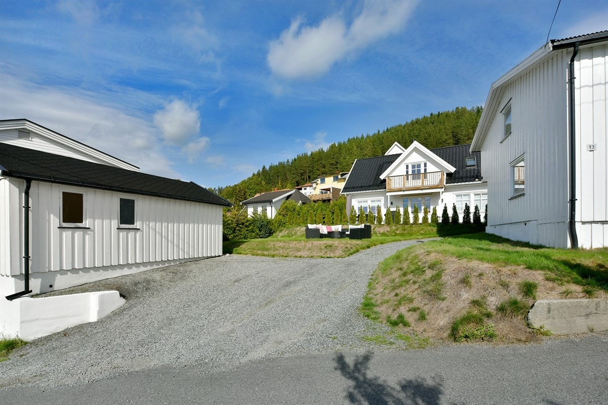 Boligen har en delvis inngjerdet uteområde opparbeidet med diverse støttemurer, skråninger og stor, gruset gårdsplass. Galleribilde