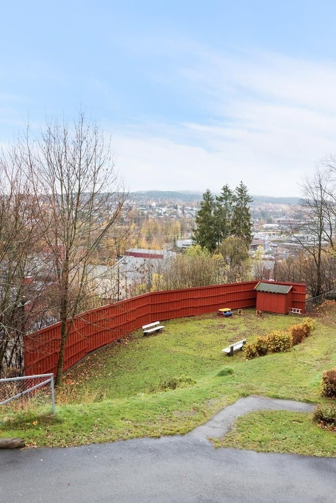 Sameiets tomt fremstår som ryddig og pent opparbeidet med plen, asfalterte internveier og hyggelig tun med benker Galleribilde