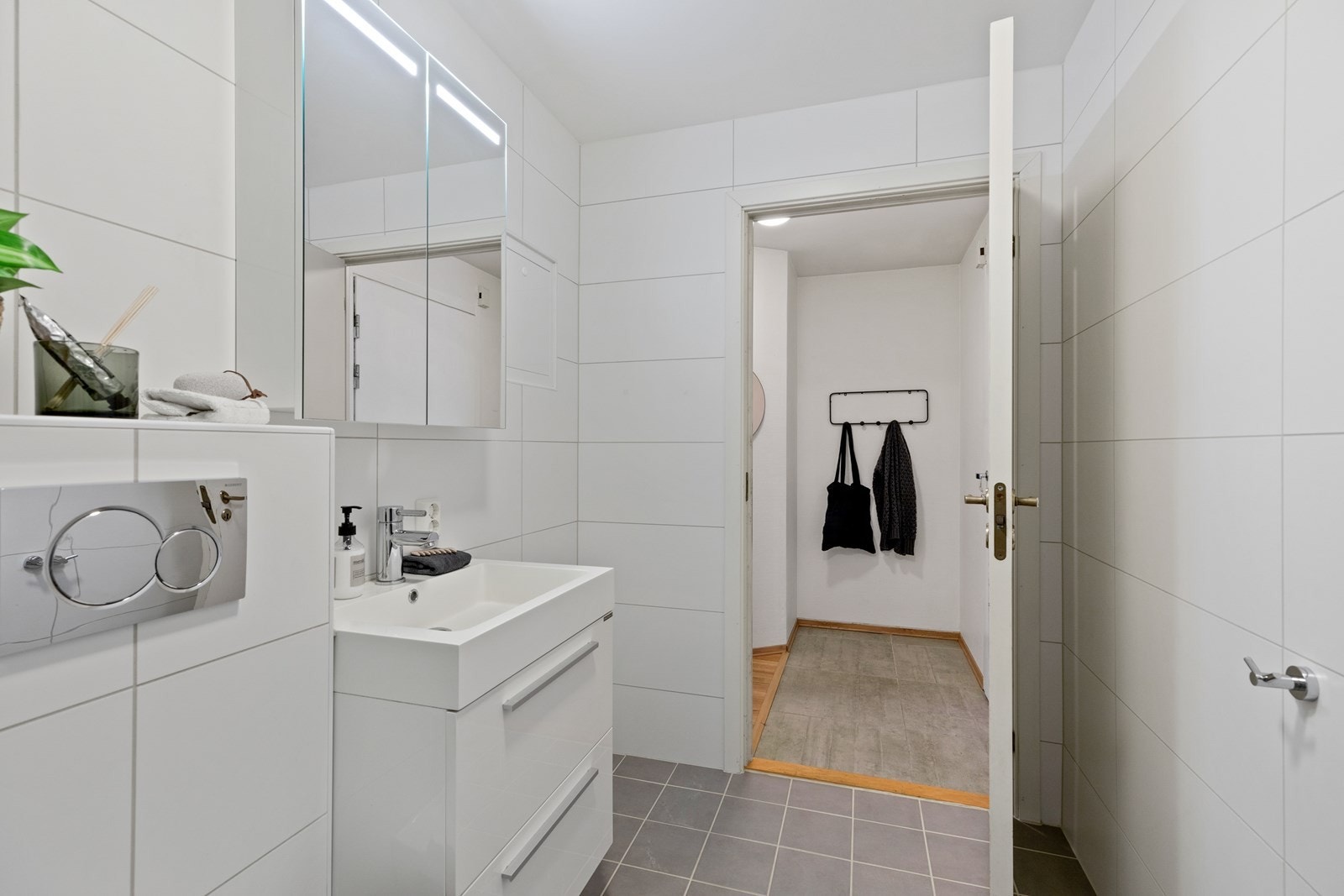 Badet har en god størrelse og opplegg til vaskemaskin/tørketrommel ved siden av baderomsinnredningen Galleribilde