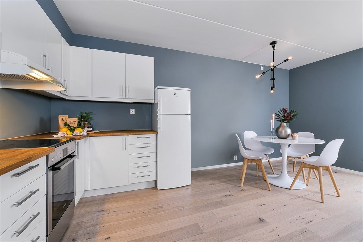 Videre er det innredning med hvite fronter, nyere benkeplate i eik med oppvaskkum i porselen, samt malte flater mellom benk og overskap. Galleribilde