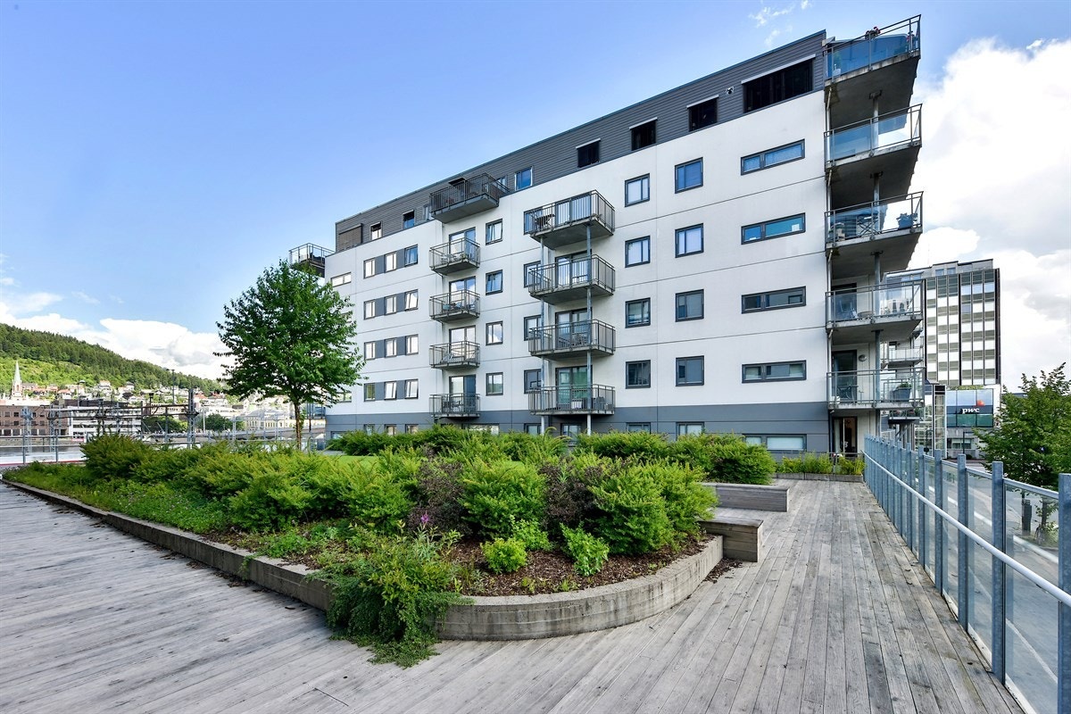 Rundt boligblokkene finnes det store områder belagt med tredekke, og muligheter for å sette seg ned å nyte en fin sommerdag. Galleribilde