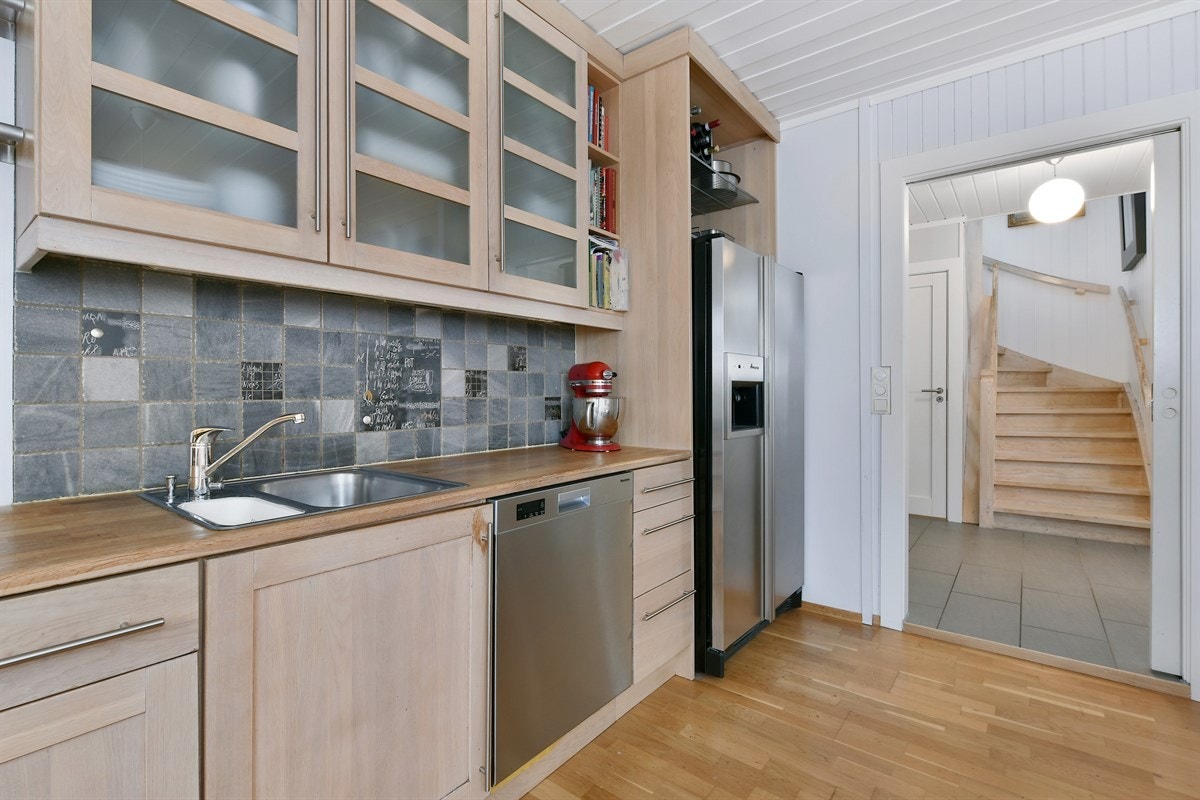 Over stekeovn og koketopp henger det en ventilator med stor stålhette. Videre er det oppvaskmaskin, mikrobølgeovn og et side-by-side kjøleskap med isbitmaskin. Galleribilde