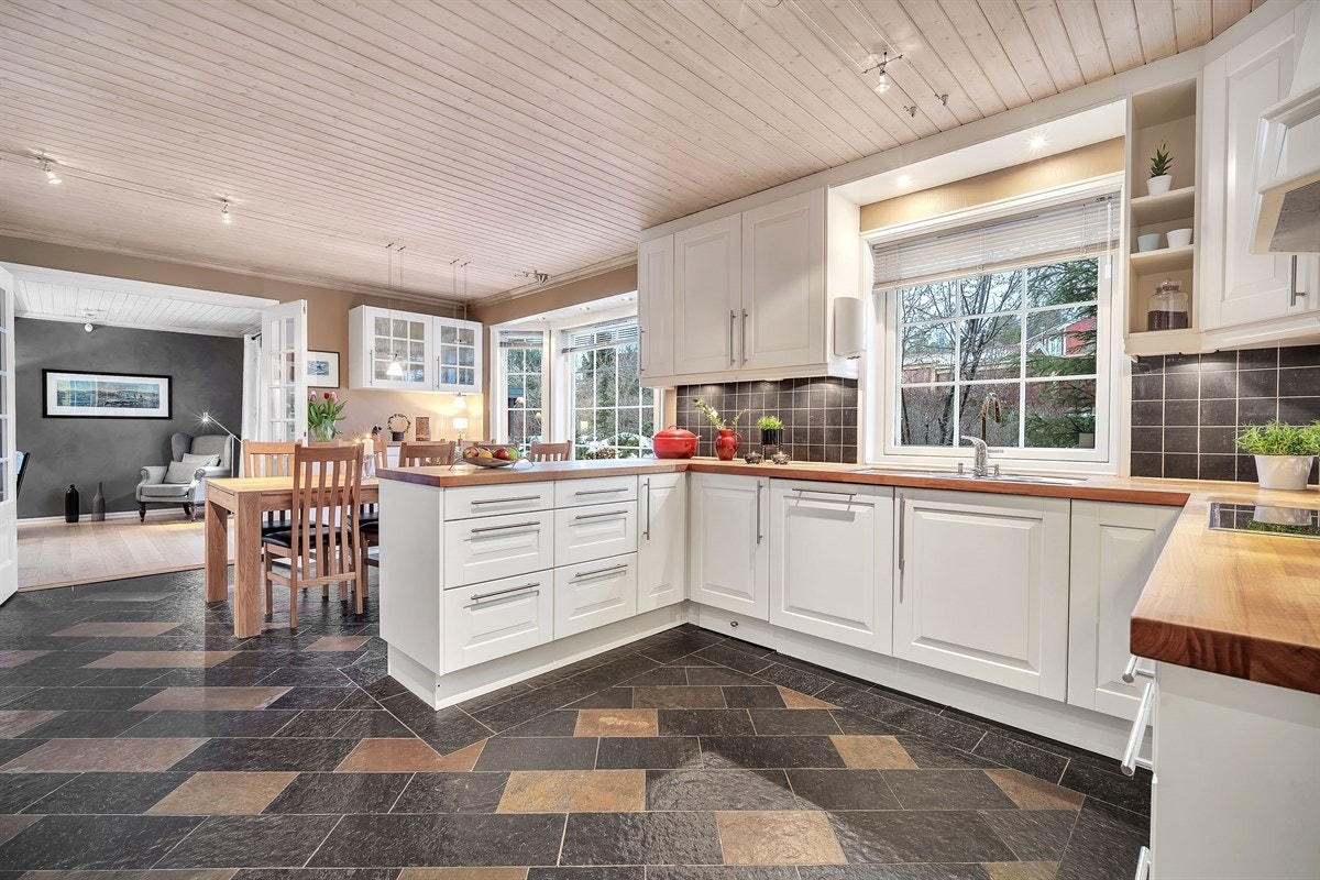 Rommet har tofarget Otta skiferfliser på gulv, gulvvarme og rikelig dagslys fra karnapp mot hage. Galleribilde