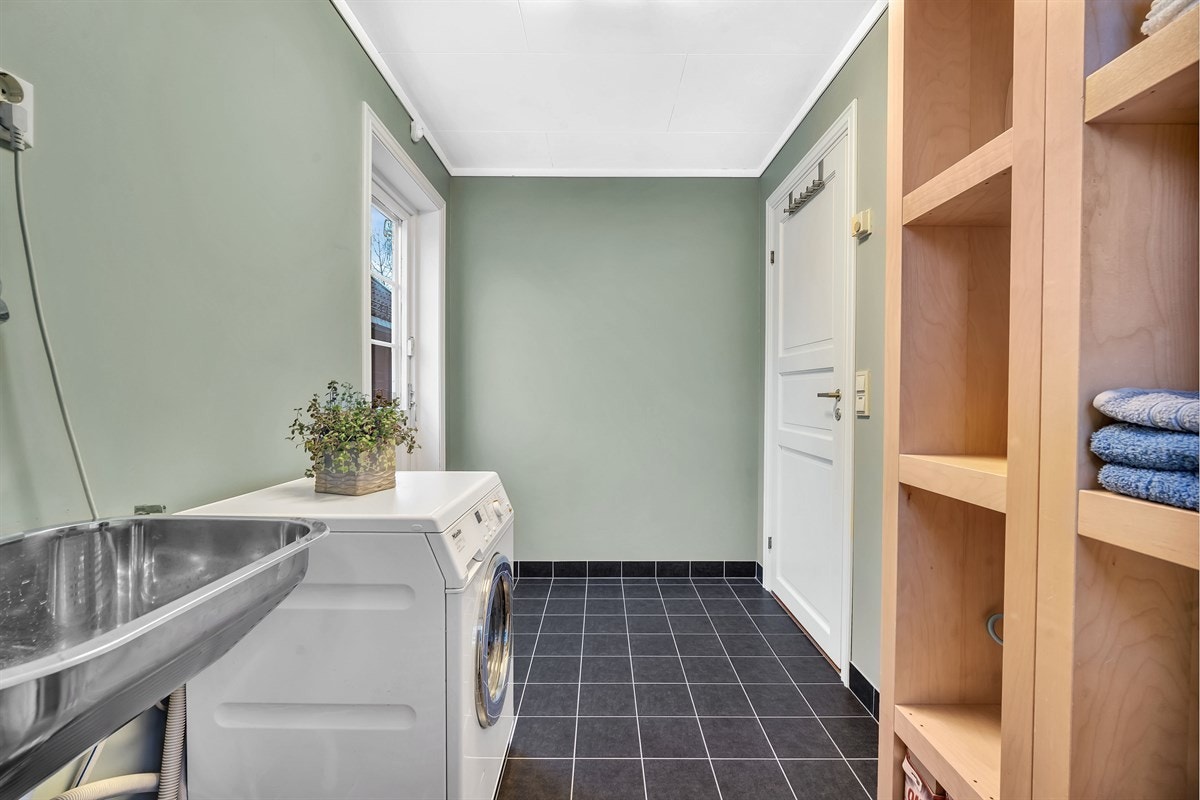 Vaskerommet har direkt utgang til gårdsplass, noe som er kjekt når smårollingene skal sluses inn med møkkete klær. Galleribilde