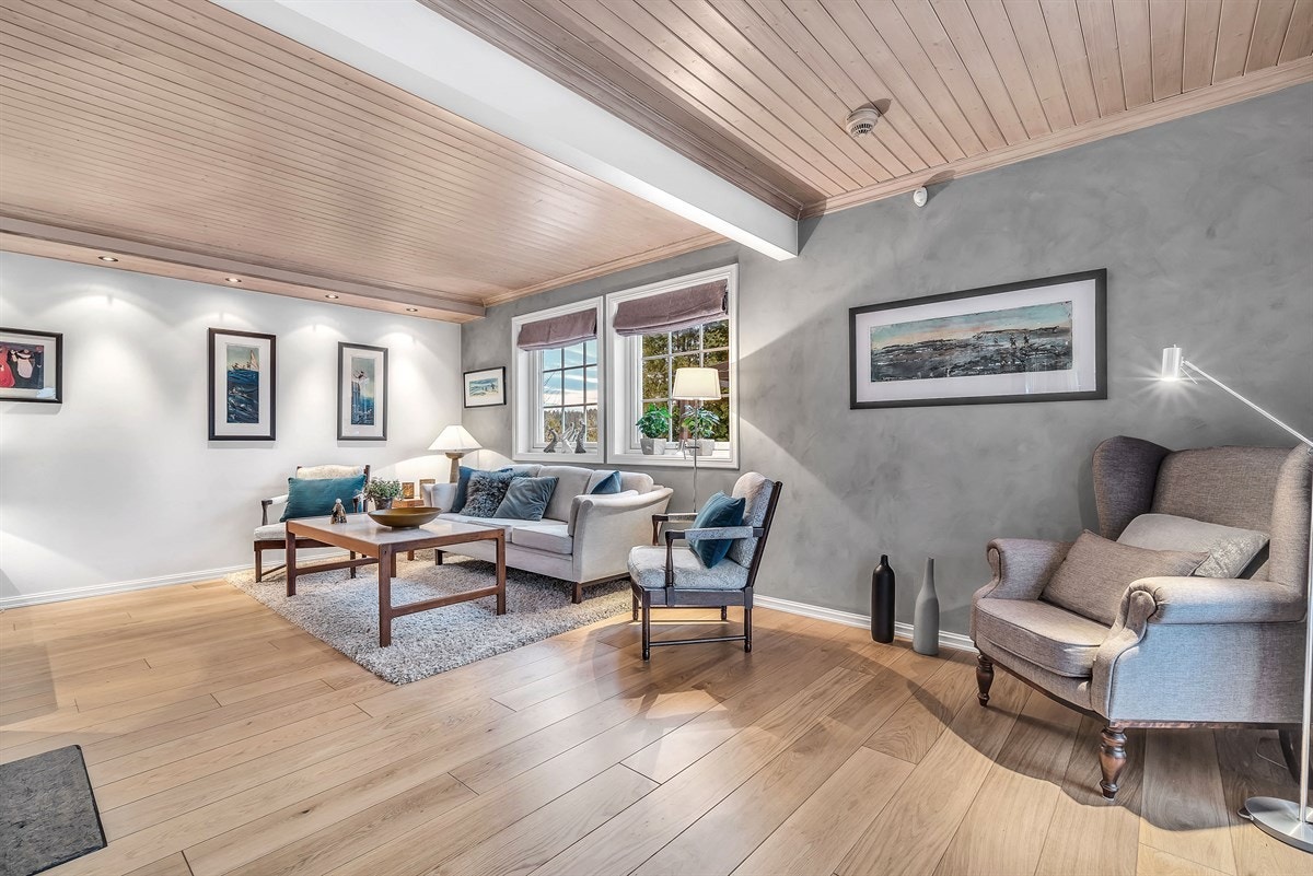 Stuen har eikeparkett på gulv med gulvvarme og en vedovn som bidrar med ekstra varme og hygge. Galleribilde