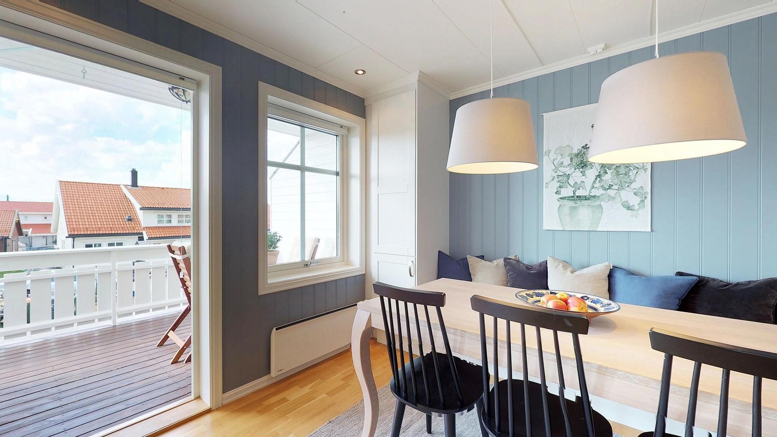 Åpen løsning mellom kjøkken og stue, med plassbygd benk ved spisebord. Fra stuen er det utgang til veranda Galleribilde