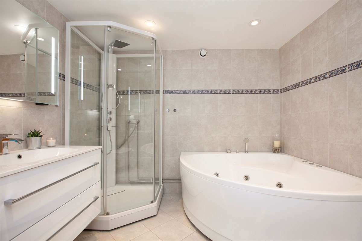 Romslig og pent oppusset bad fra 2005 (innredning fra 2016). Badet har flislagte gulv og vegger, samt gulvvarme og nedsenket himling med downlights. Galleribilde