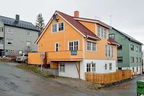 To vinduer på toppen av gult hus er med hybel 3. Galleribilde