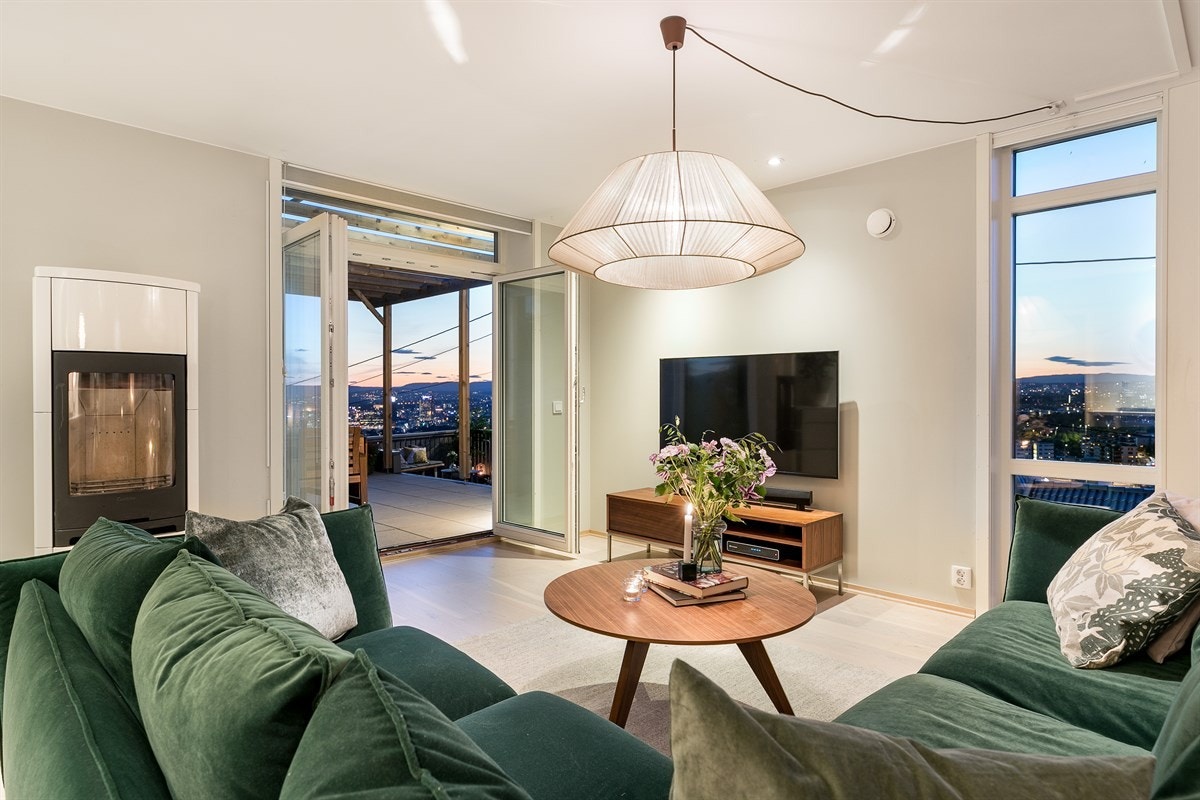 En dekorativ, hvitlakkert peisovn setter stemningen i rommet når du tenner opp på kjølige dager. Galleribilde