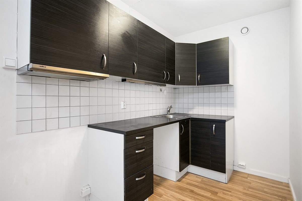 Lekkert kjøkken med slette fronter og laminat benkeplate. Galleribilde