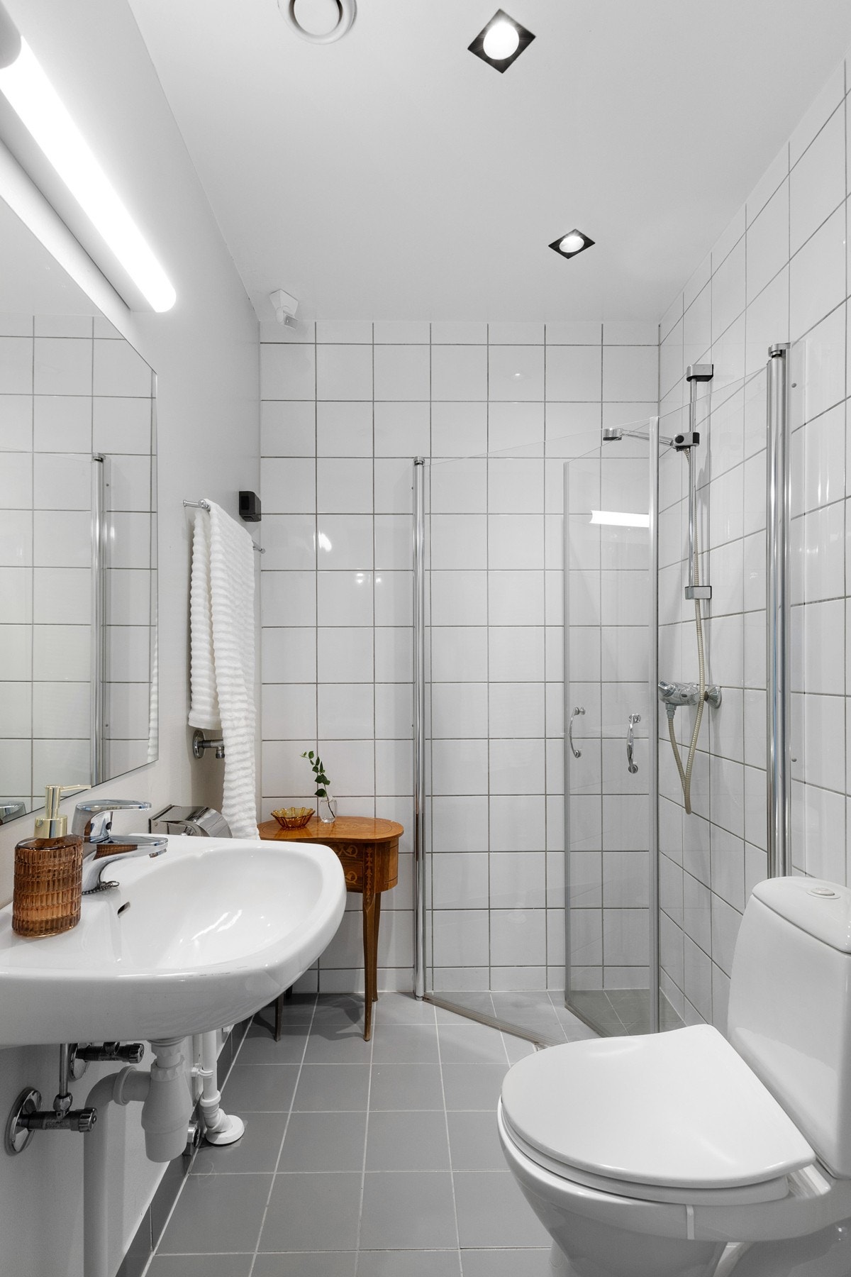 Badet har lyse fliser, malte overflater og downlights i himling. Galleribilde