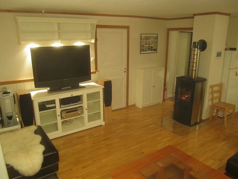 Stue med god planløsning og effektiv peisovn Galleribilde