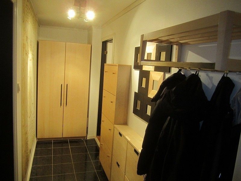 Flislagt gang med stort garderobeskap og praktiske skoskap Galleribilde