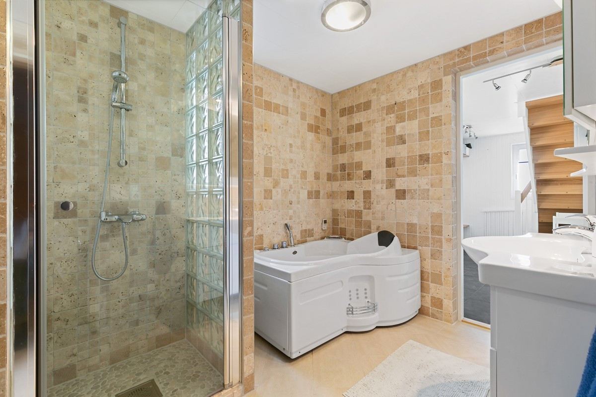 Komplett fliselagt baderom i 1. etasje med dusj, badekar og wc