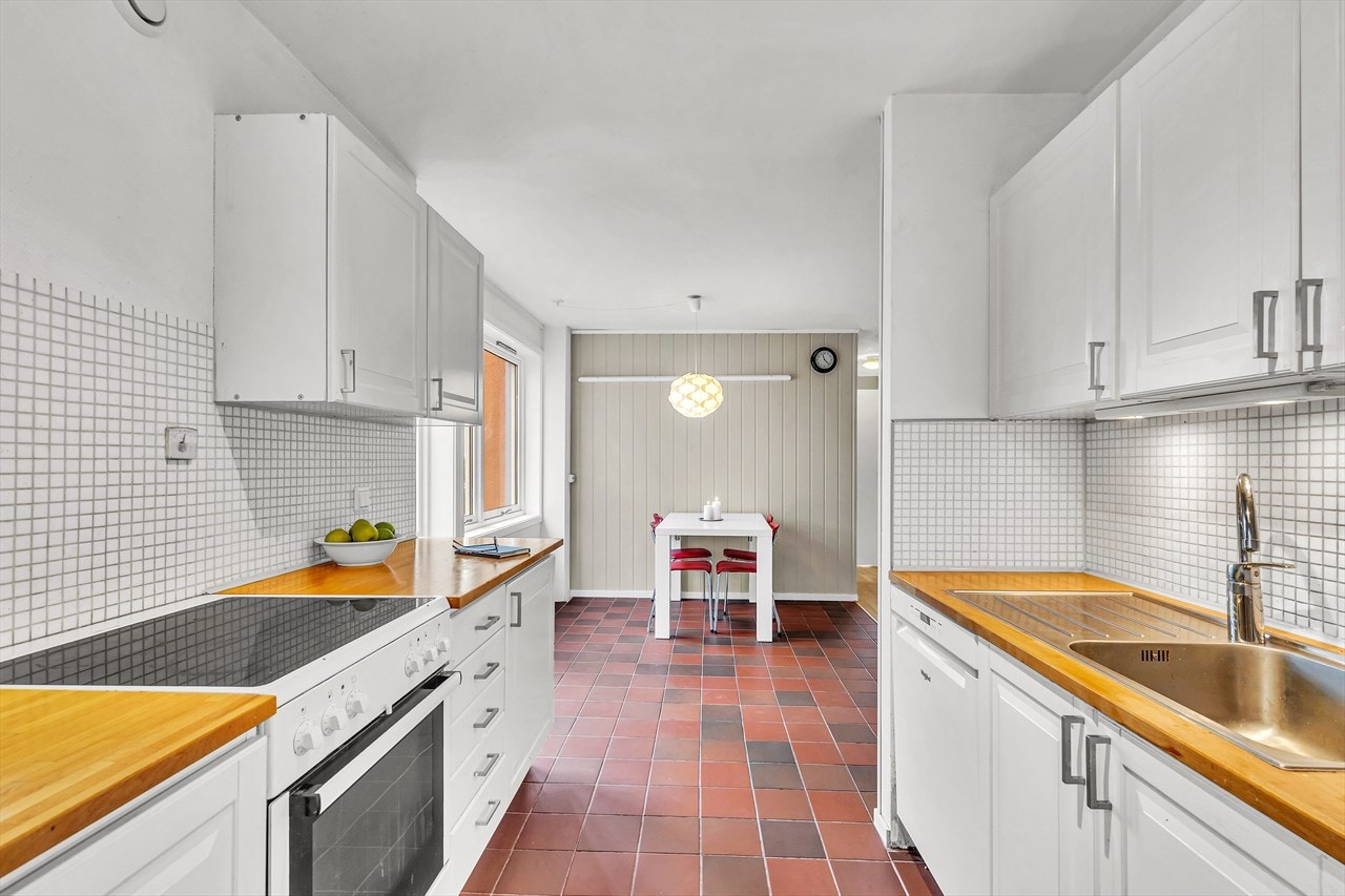 Kjøkkenet har flislagt gulv, nye fronter på innredningen samt godt med benkeplass Galleribilde