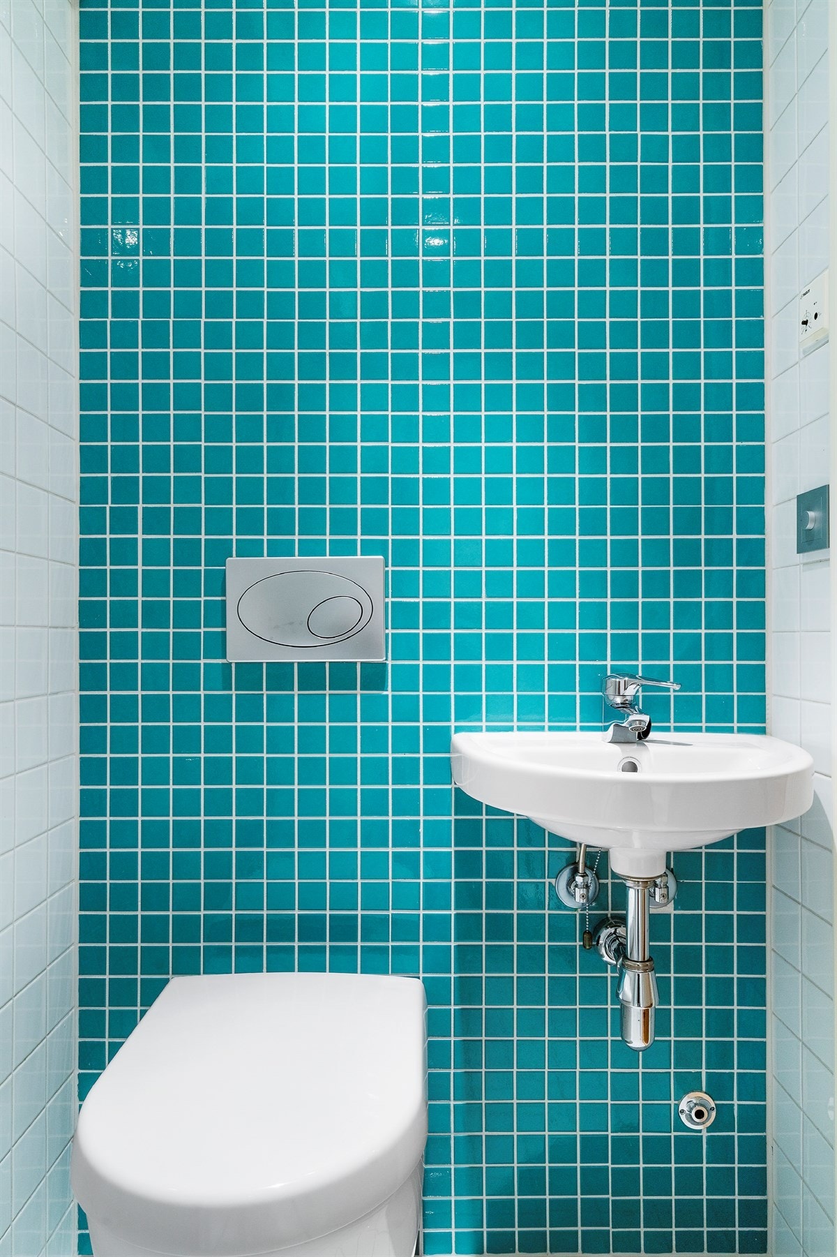Proaktiv - Badet er utstyrt med dusjnisje med skyvedør, vegghengt toalett og vask på vegg. Galleribilde