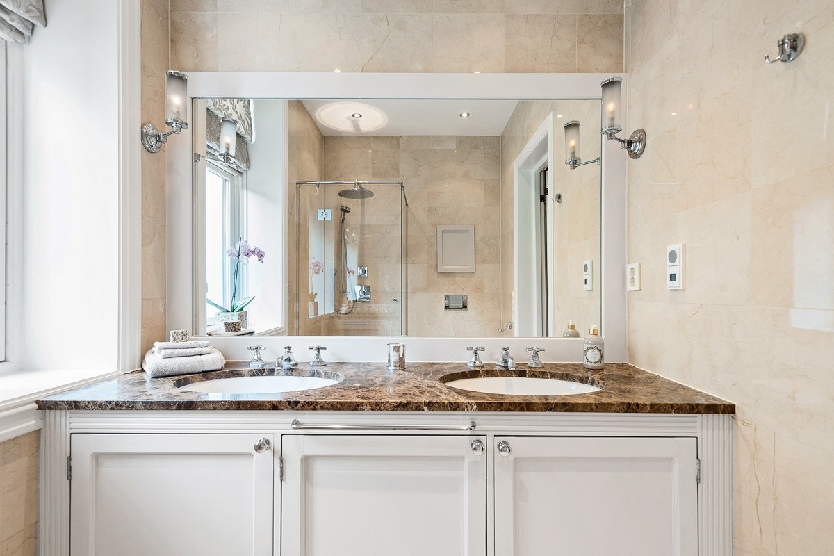 Badet er innredet med vegghengt toalett med innebygget sisterne, plassbygget møbel med 2 servanter Galleribilde