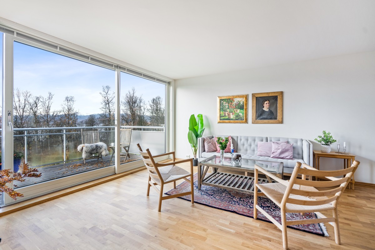 Lys og lekker stue med store vindusflater, rikelig med lysinnslipp og ingen innsyn