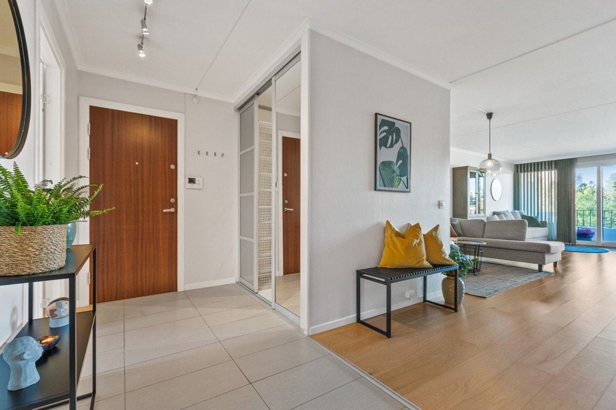 Innbydende entré med stor walk-in garderobe innredet med kurver, hengestang og hyllesystem Galleribilde