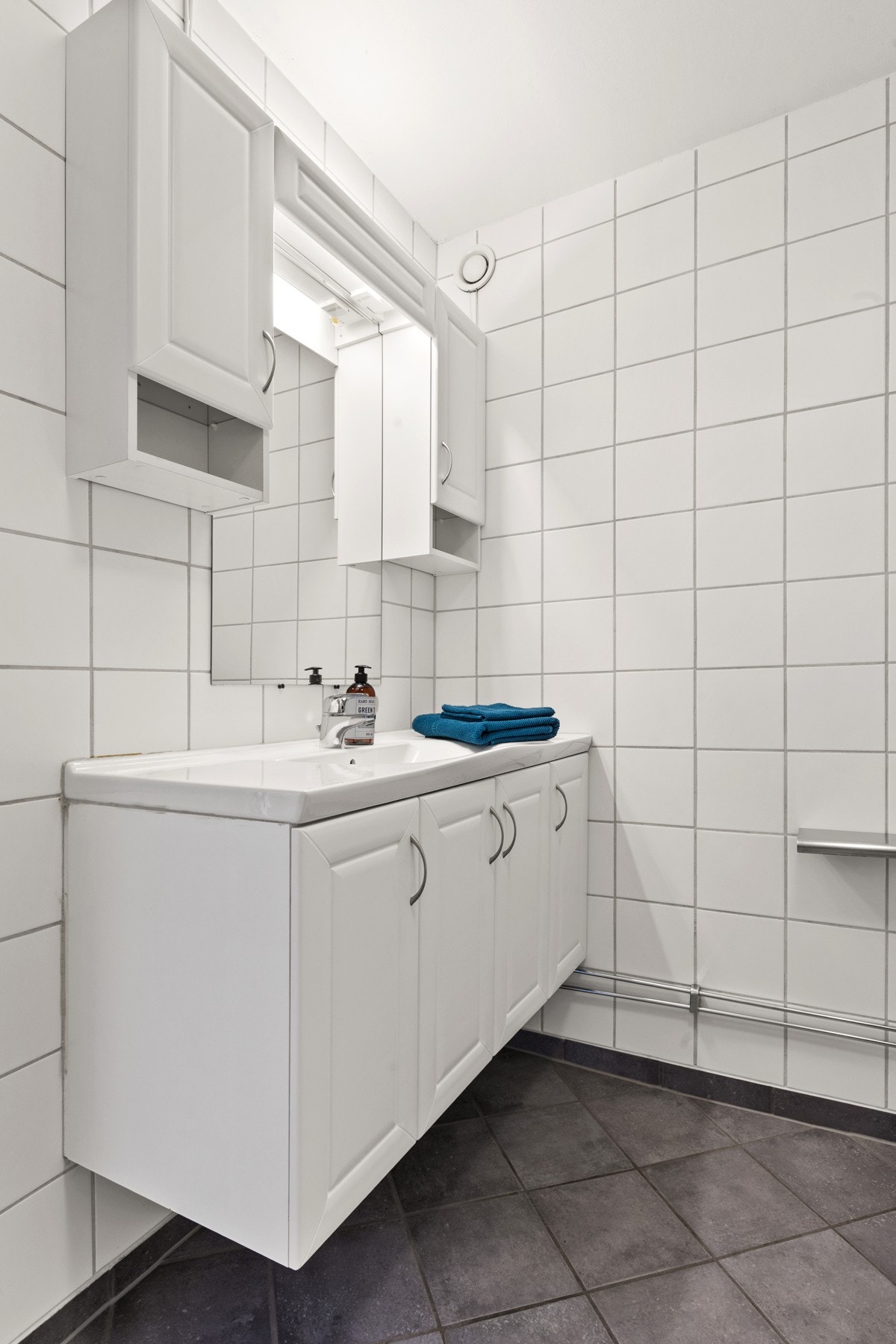 Badet er innredet med wc, baderomsinnredning med heldekkende servant og innmurt flislagt badekar med dusj og sprutdemper m.m. Galleribilde