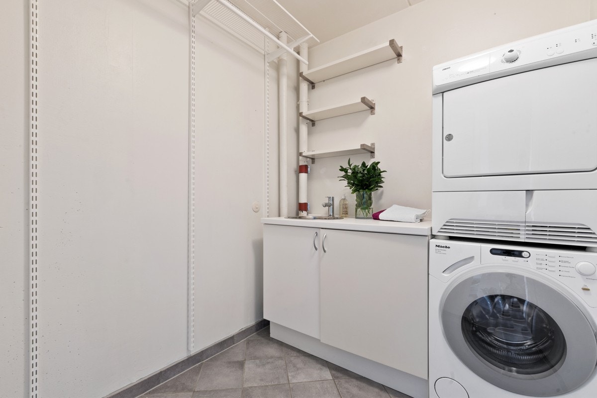 Praktisk vaskerom med skapinnredning og opplegg for vaskesøyle Galleribilde