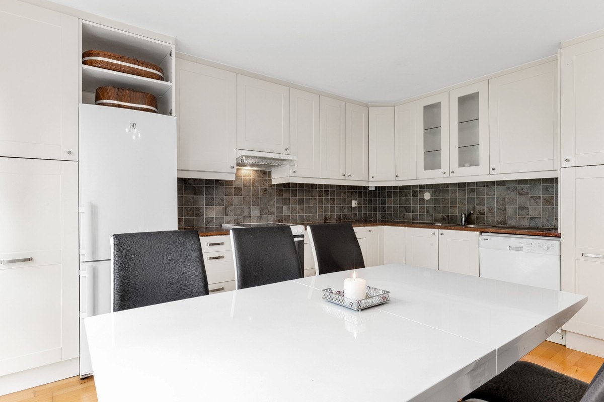 Kjøkkeninnredning er lys med profilerte fronter og lakkert, heltre benkeplate. Galleribilde