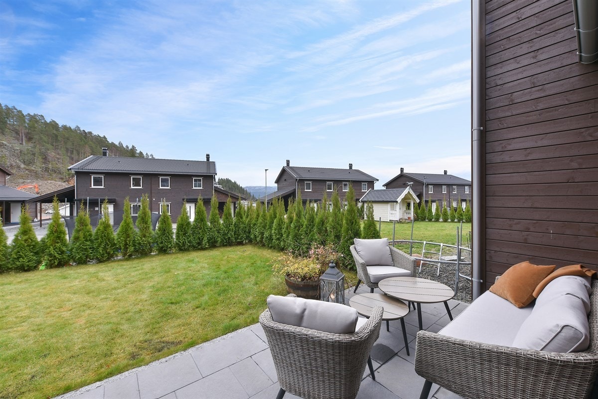 Boligen har en steinlagt markterrasse på ca. 25 kvm med lettstelt hage med plen. Hagen er innrammet av tujahekk. Galleribilde