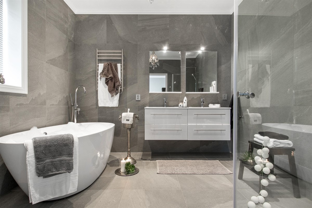 Badet har store, grå fliser med struktur, downlights og gulvvarme. Galleribilde