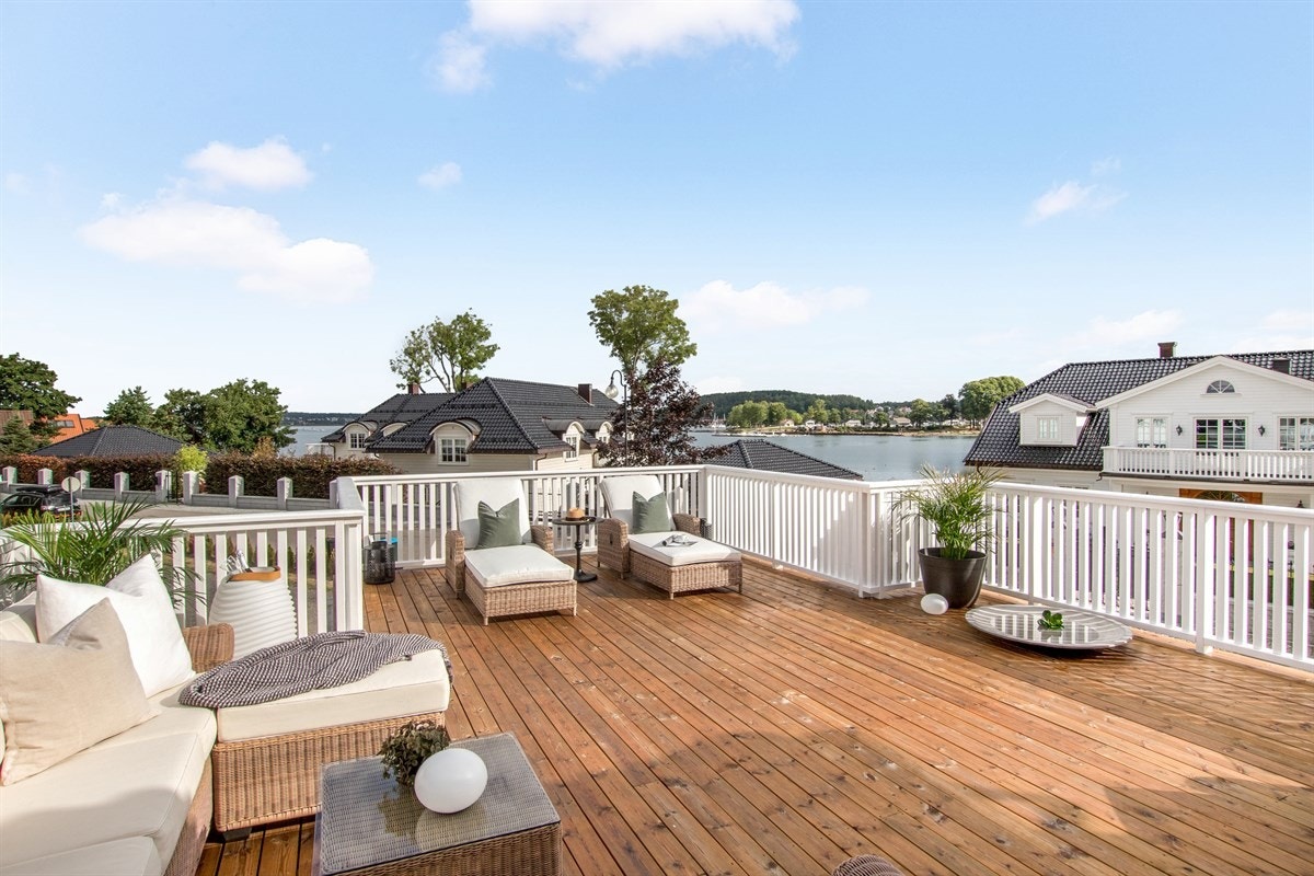 I andre etasje er det i tillegg en flott terrasse med tregulv og hvitmalt rekkverk, hvor kun fantasien setter begrensninger for møblering. Galleribilde