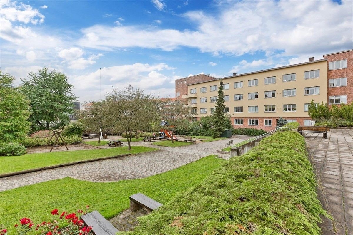 Parkmessig bakgård med felles sittegrupper, lekeplass og grill Galleribilde