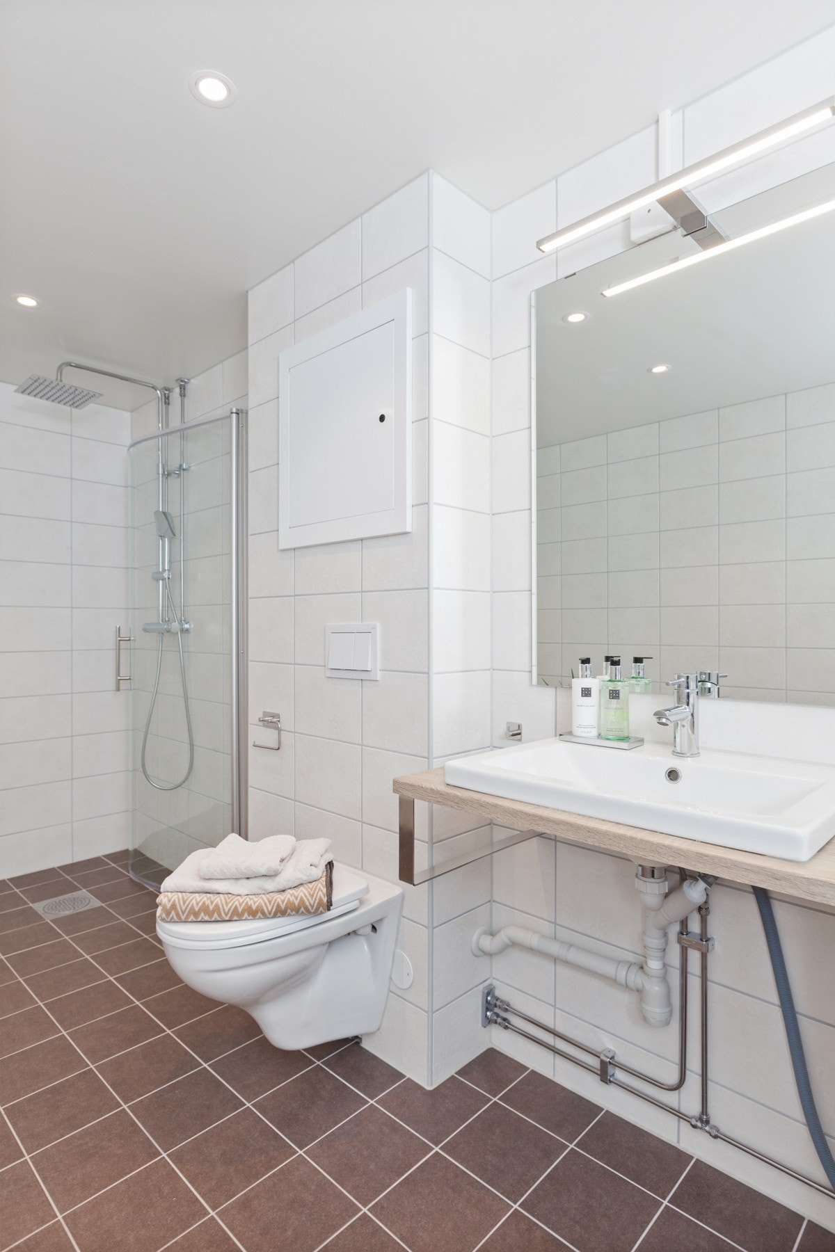 Meget stort baderom oppusset i 2019 med delikate grå fliser på gulv med varmekabler Galleribilde