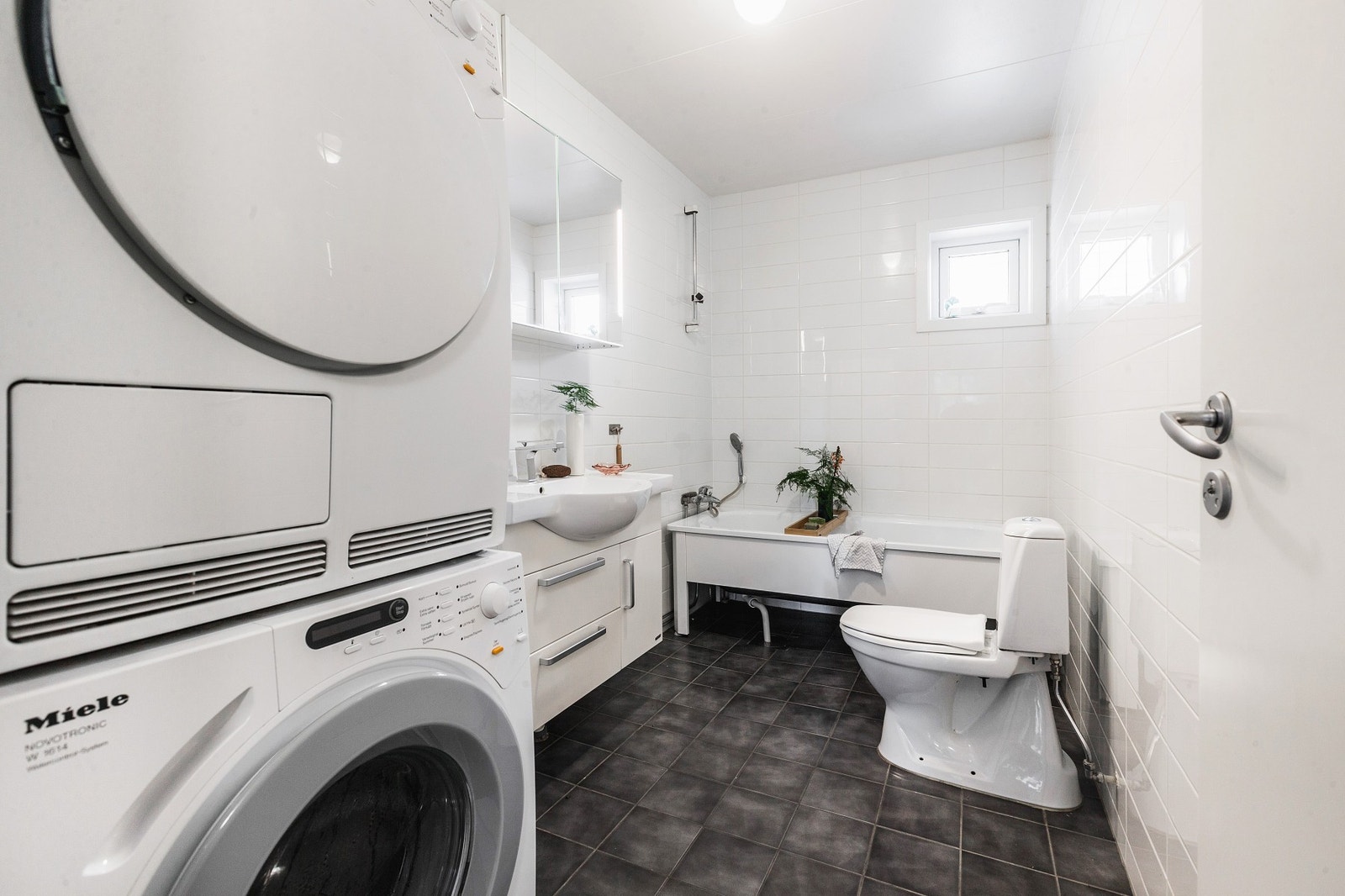 Badet er lyst og romslig, innredet med flislagte overflater og innredning i hvitt. Galleribilde